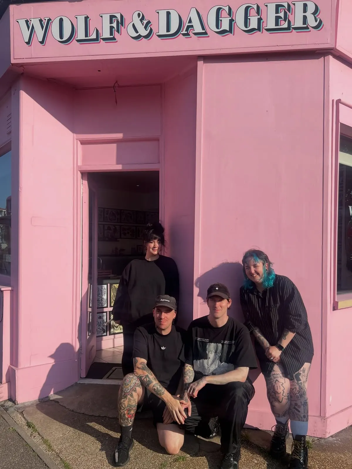 Wolf & Dagger artists sitting outside the studio doorway in Hove